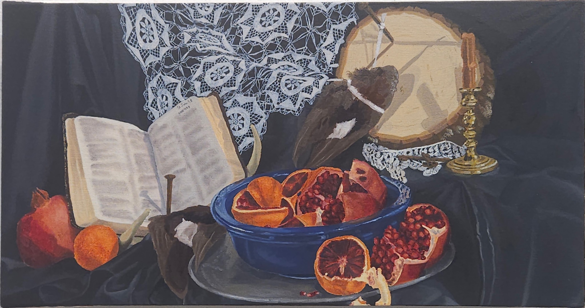 Still life with open book, fruit, drum, and lace cloth on dark background.