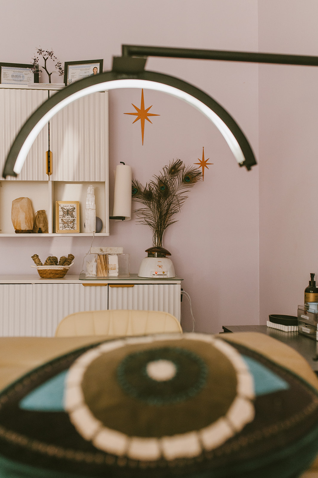 Interior room with a decorative star wall hanging, a plant, and shelves with various items.