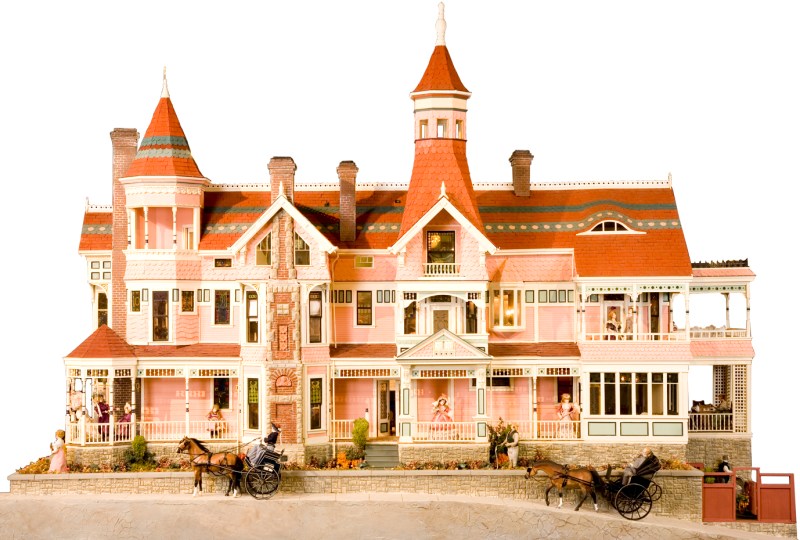 Pink castle-like building with towers, balconies, and horse-drawn carriages in front.