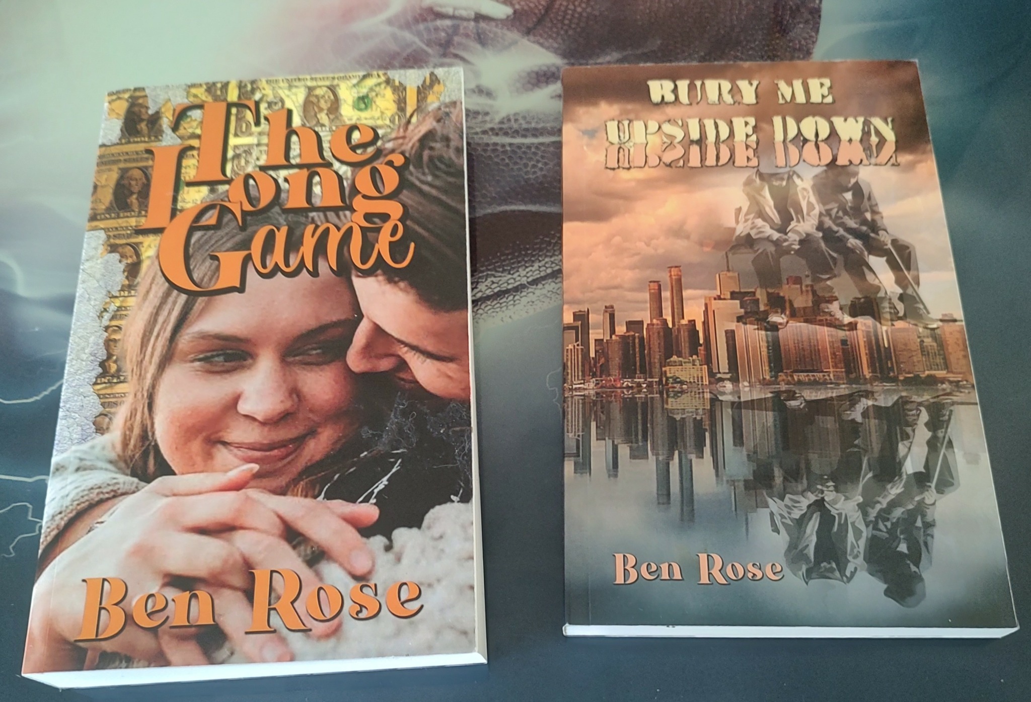 Two books titled 'The Long Game' and 'Run Me Under Now' by Ben Rose, with cityscape and person on covers.
