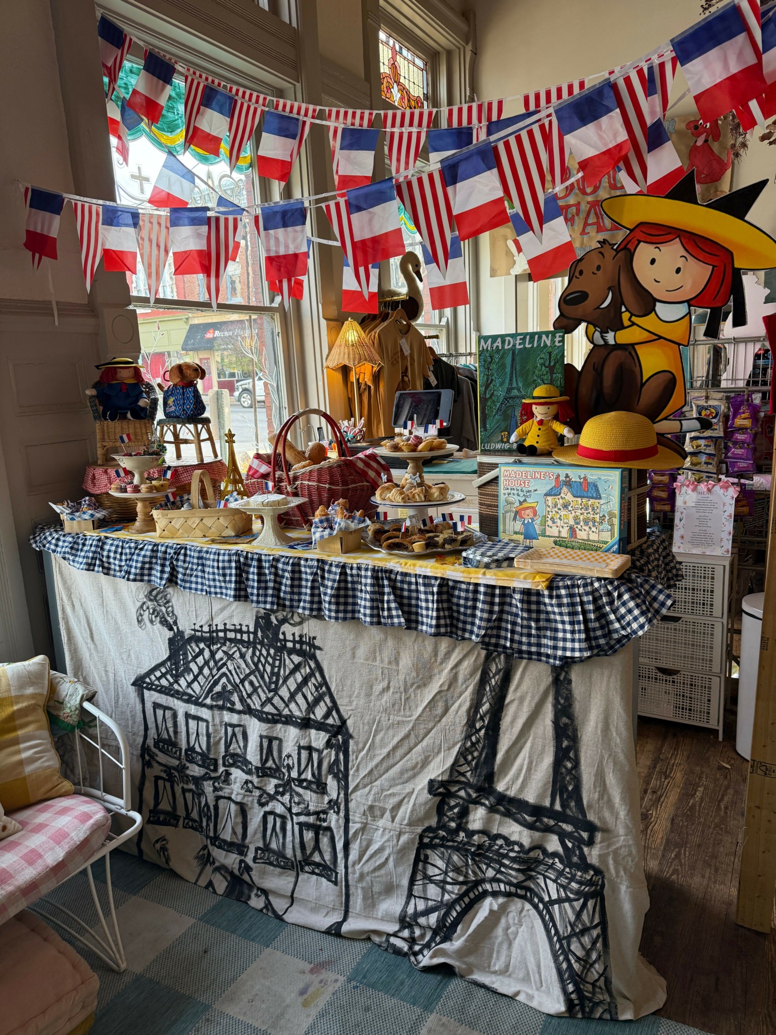 Decorated table with British flags, cartoon characters, and a cake, celebrating a patriotic event indoors.