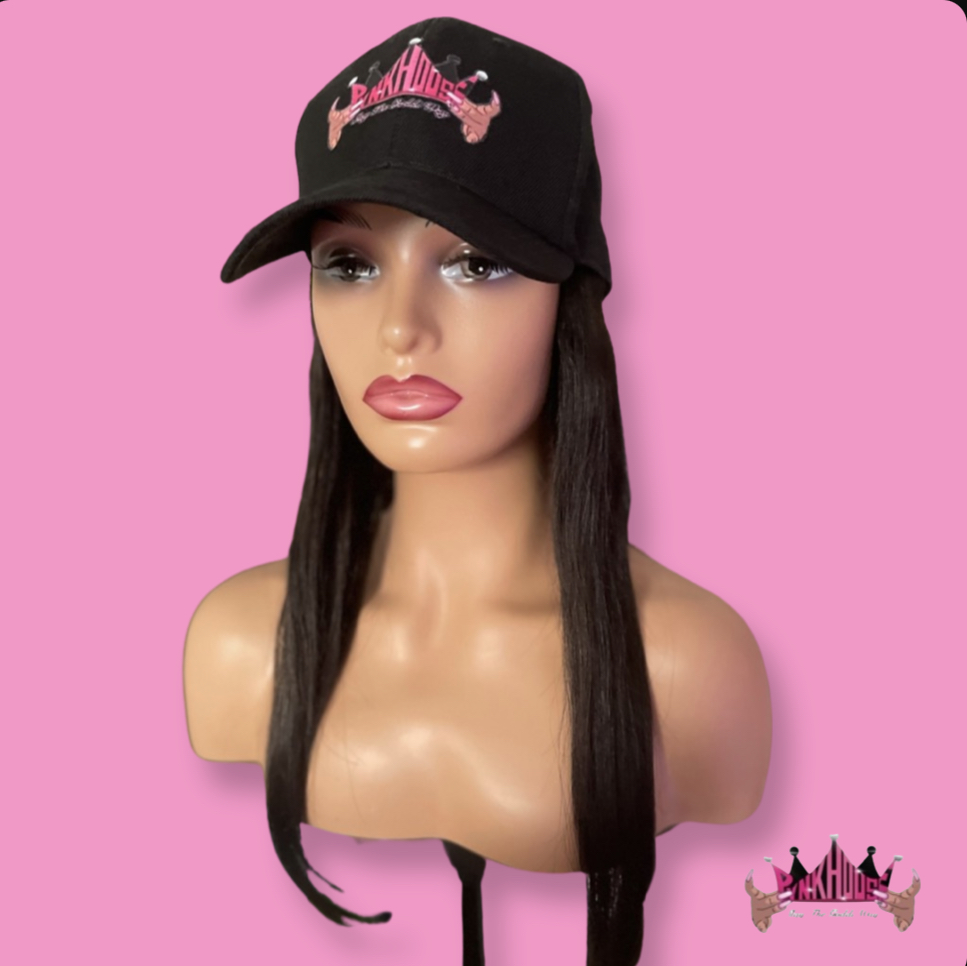 Mannequin head with long black hair, wearing a black cap with pink embroidery, against a pink background.