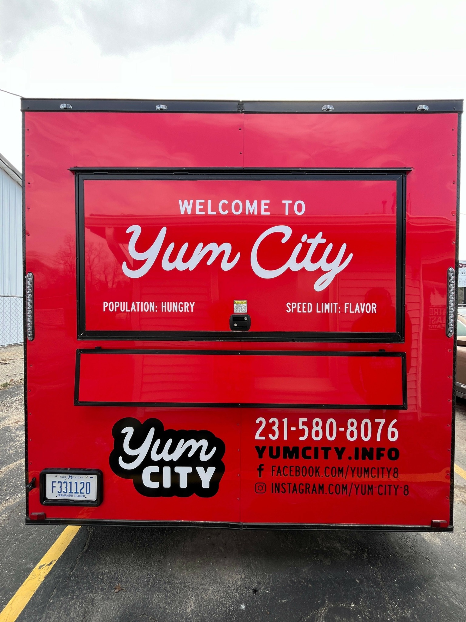 Red Yuma City welcome sign with white and black text, including phone number and website, on a black background.