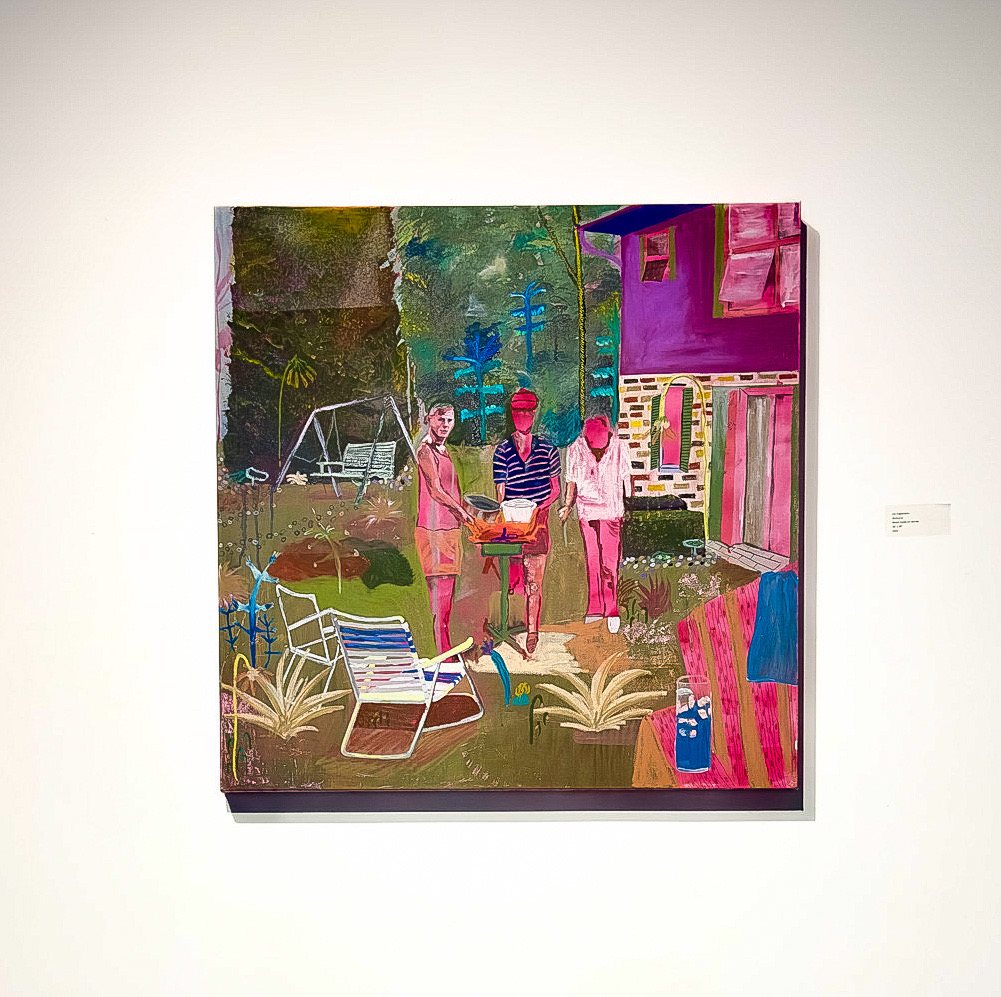 Three people standing outdoors near a house with colorful walls, surrounded by plants and outdoor furniture.
