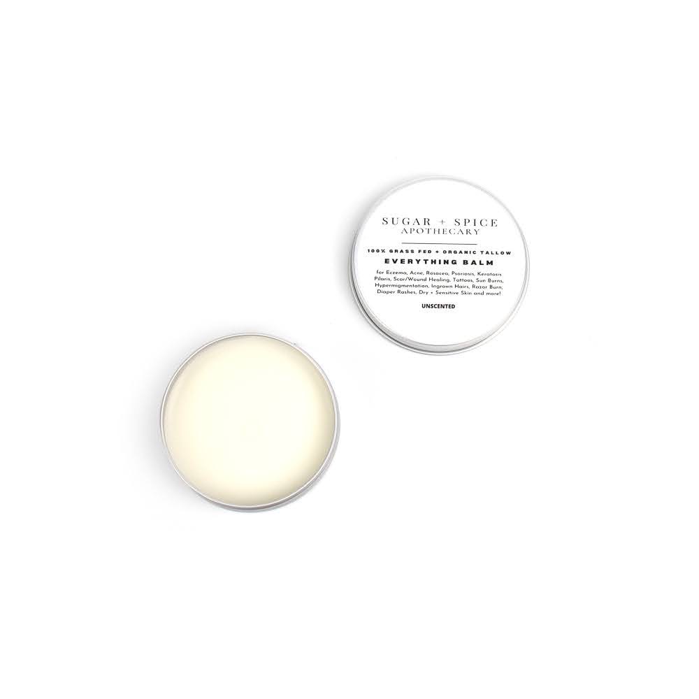 Open container with white balm and lid with text, on white background.