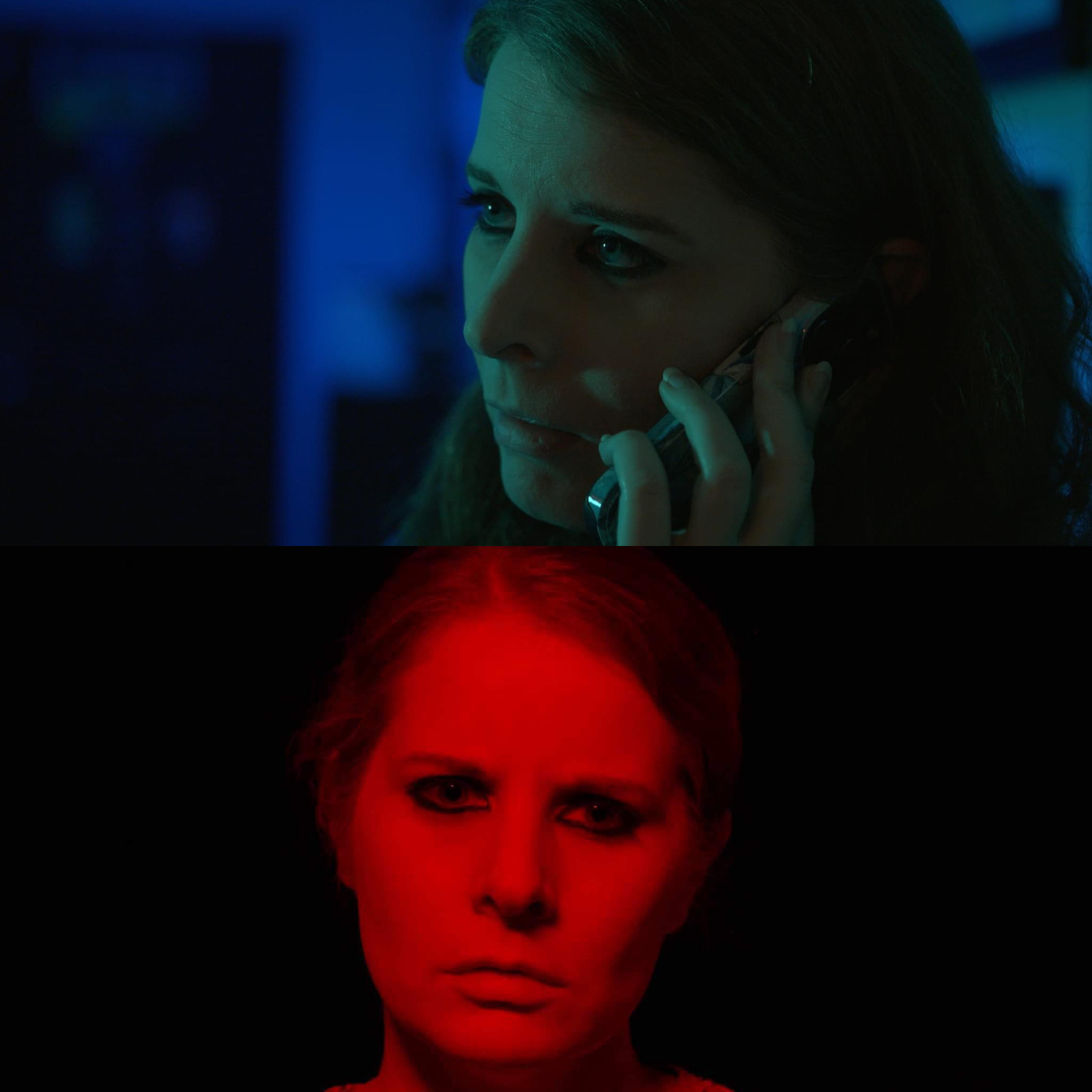 Woman with serious expression talking on phone, illuminated by blue and red lighting, dark background.