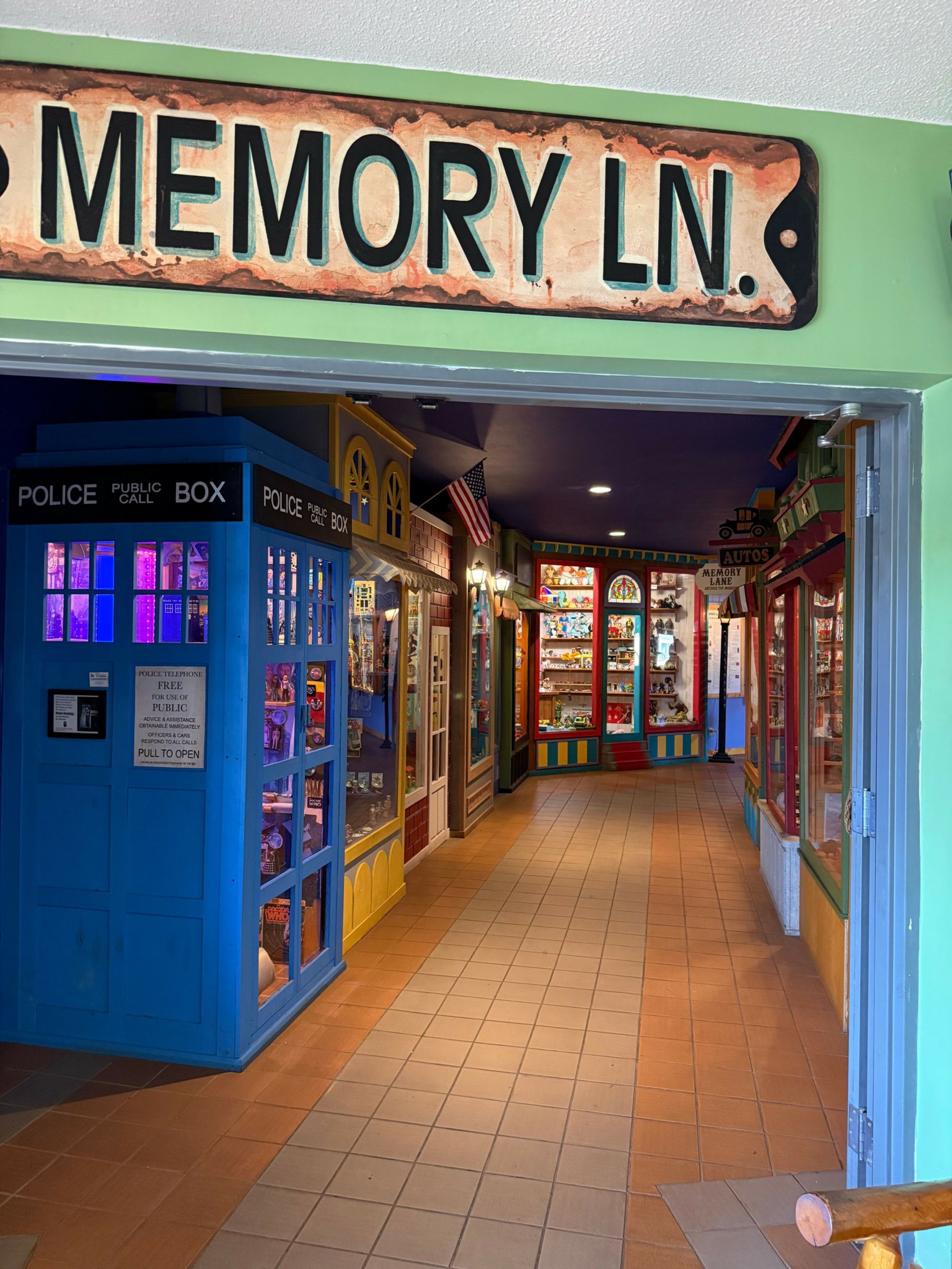 Vending machine with purple lights inside, hallway with colorful doors, and a sign reading 'MEMORY LN.'