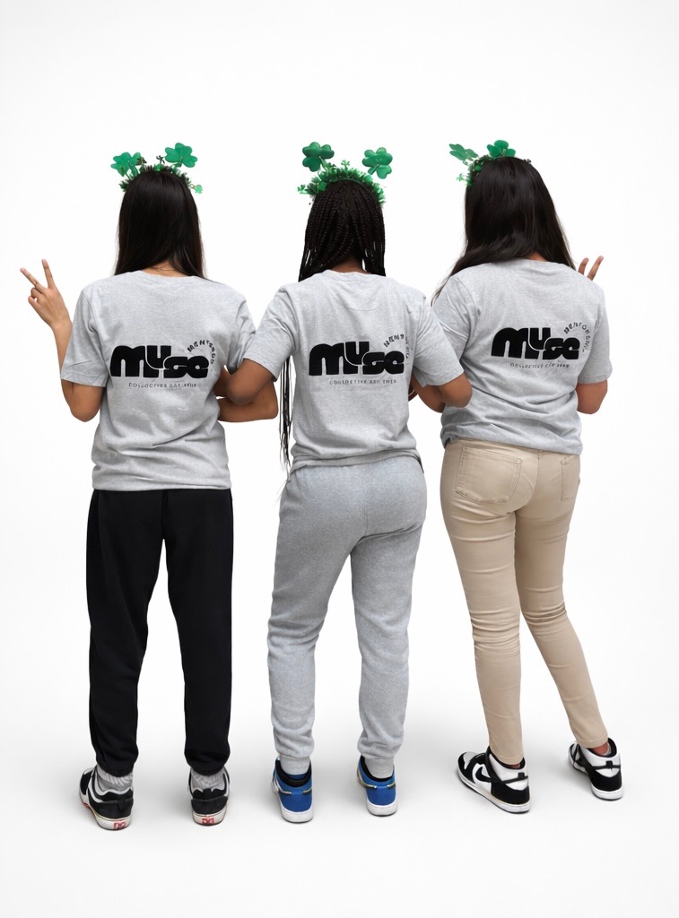 Three people standing with their backs, wearing gray shirts and festive headbands, making peace signs with their hands.