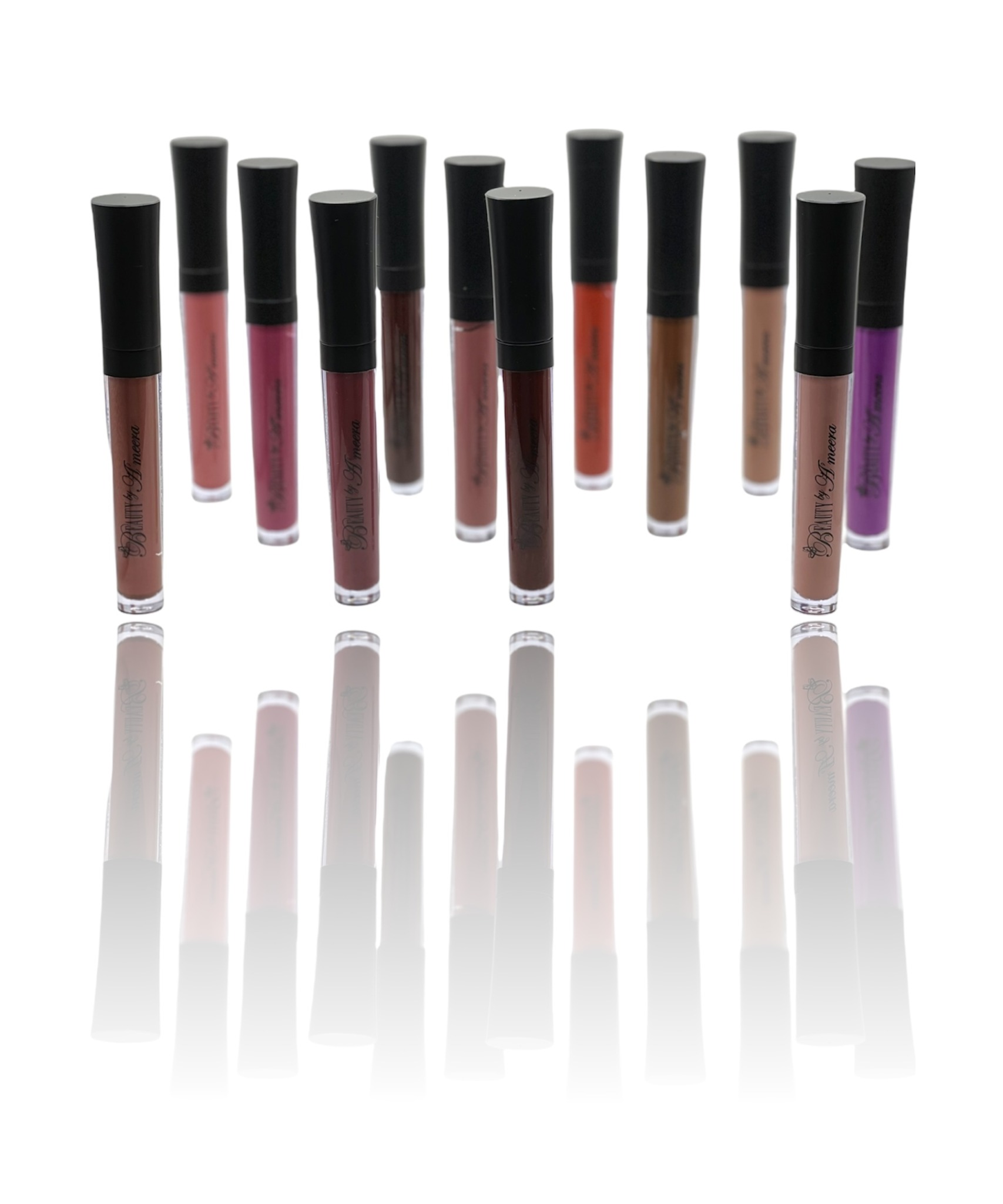 Collection of 12 lip gloss tubes with black caps, arranged in a row, reflected on a white surface.