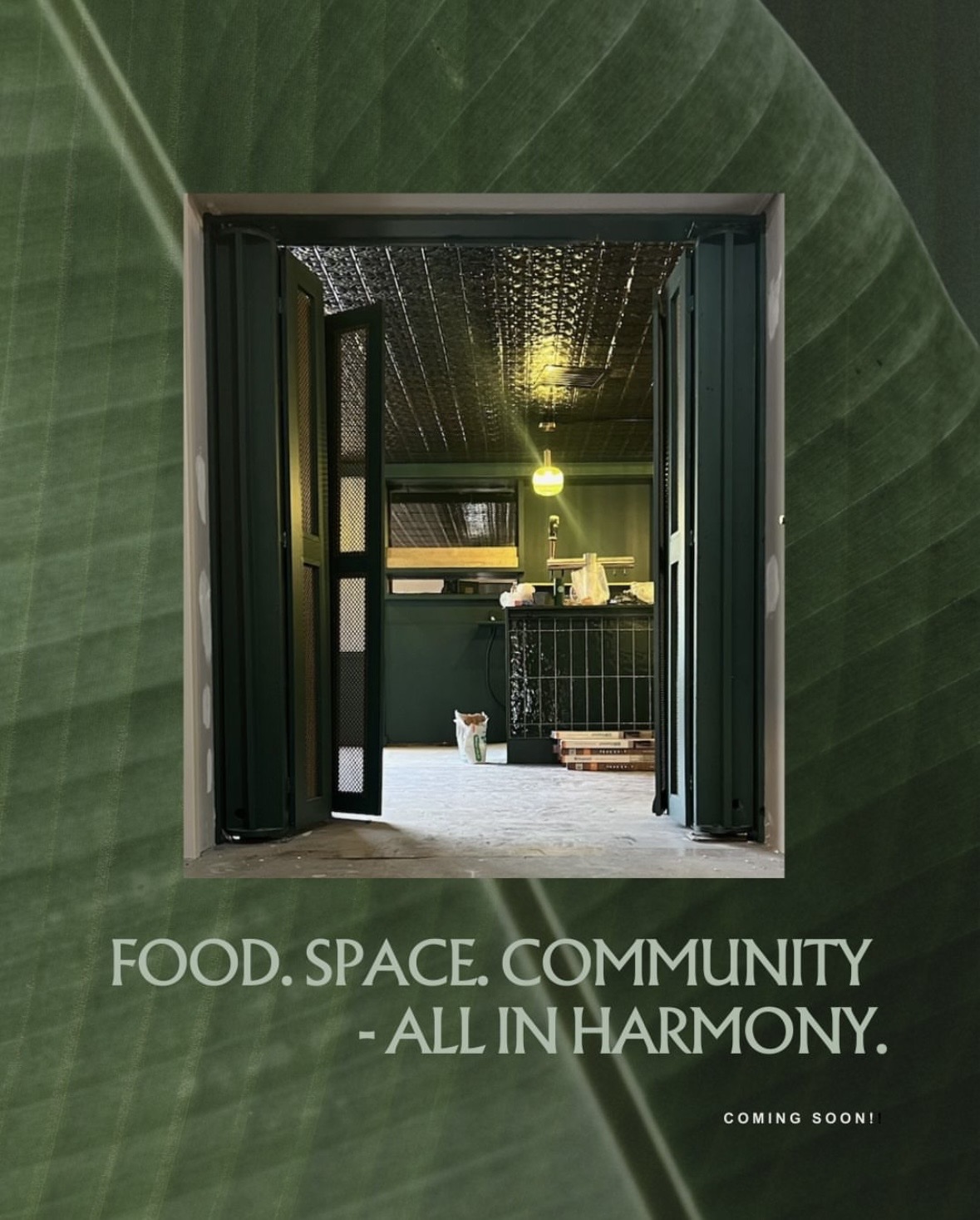 Open doorway revealing a cozy interior with a table, chairs, and hanging lights, framed by large green leaves outside.