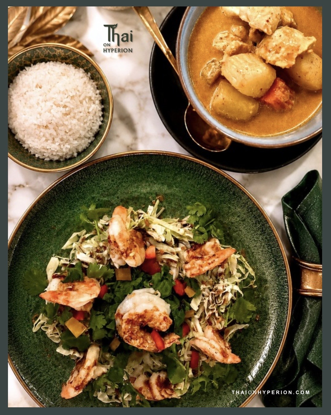 Salad with shrimp, rice, and curry dish on a table, with a green plate and bowl of rice, viewed from above.