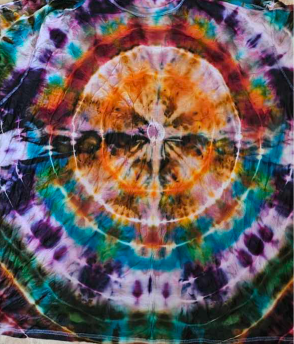 Colorful tie-dye fabric with concentric circles and a central figure resembling a person with outstretched arms.