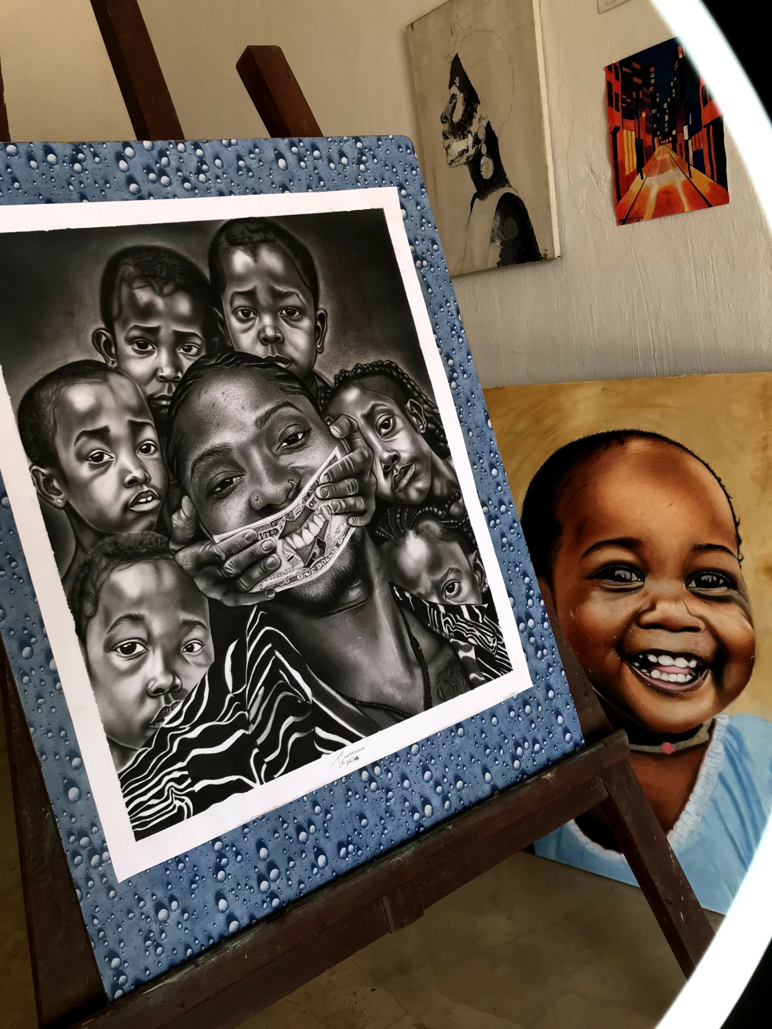 A framed black-and-white photo of children and an adult, with a smiling child beside it, on a table.