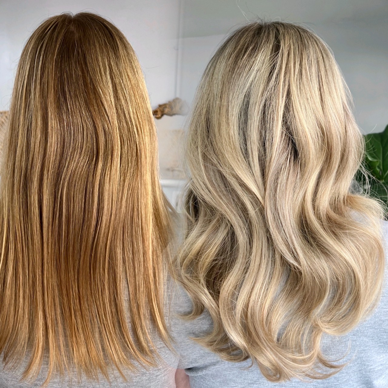 Two women with different blonde hair styles, one with straight hair and the other with wavy hair, viewed from the back.