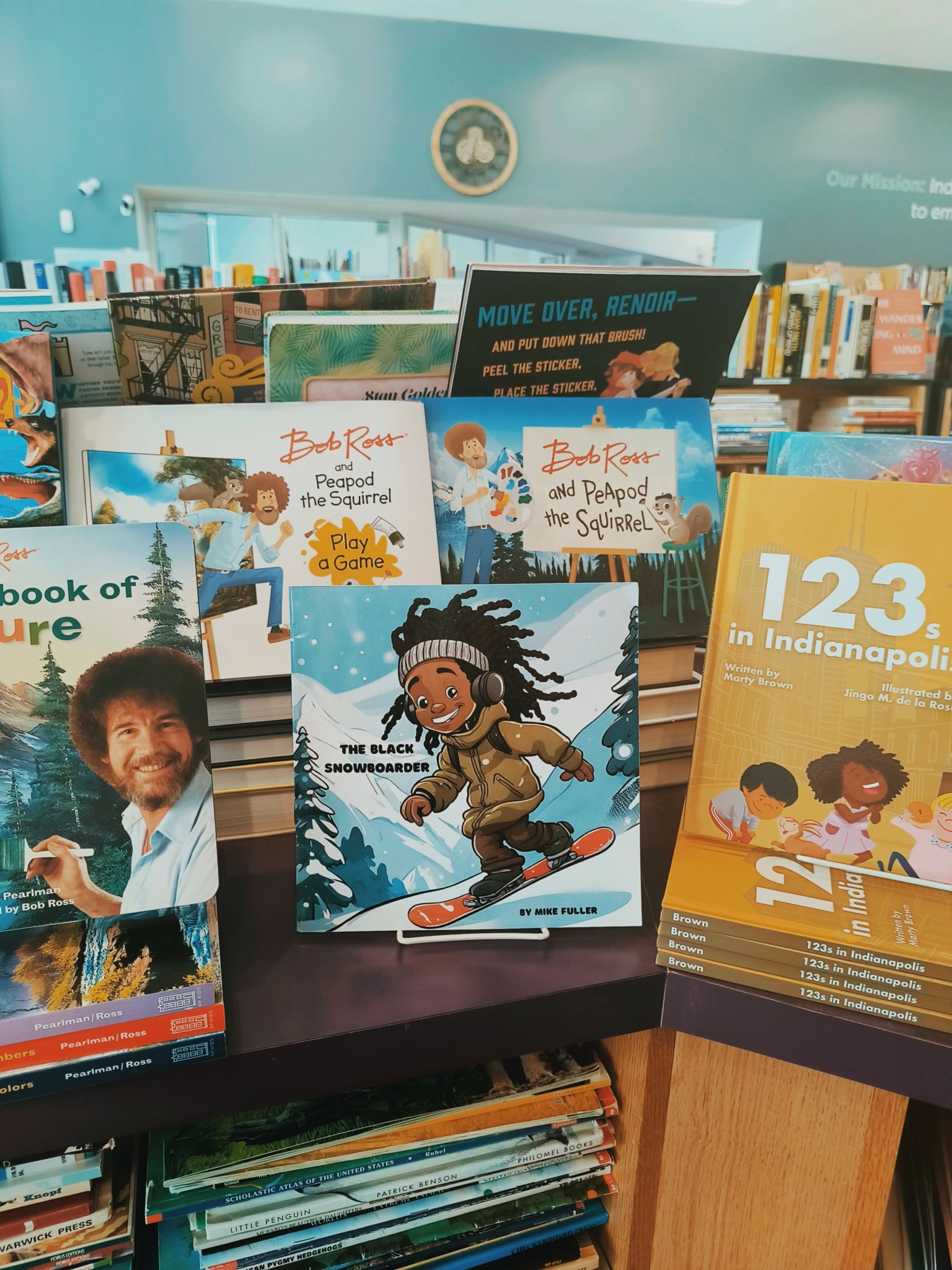 Books displayed on a shelf in a library, including children's books and educational materials.