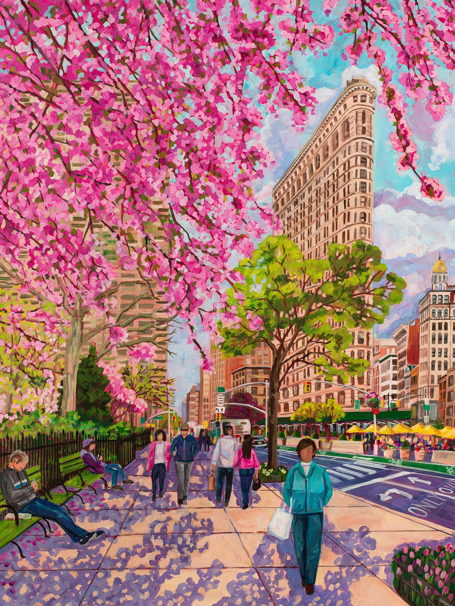 City street with pink flowering trees, people walking, and tall buildings, including the Flatiron Building, under a partly cloudy sky.
