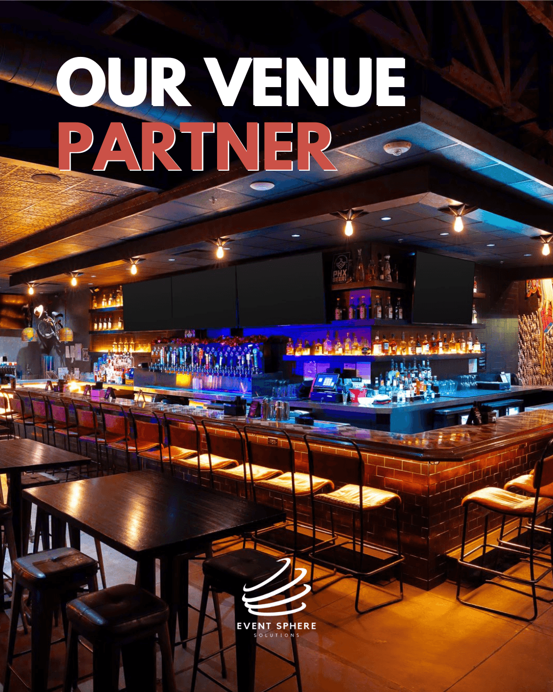 Bar with illuminated shelves, seating, and a ceiling with recessed lighting, in a dimly lit venue.
