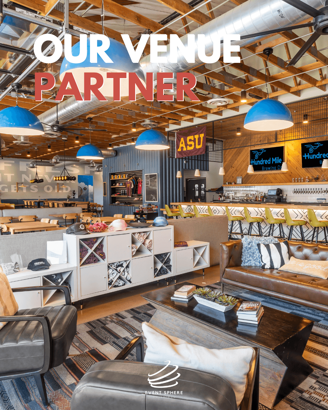 Interior of a modern venue with seating, bar area, and blue pendant lights, featuring signs for ASU and other screens.