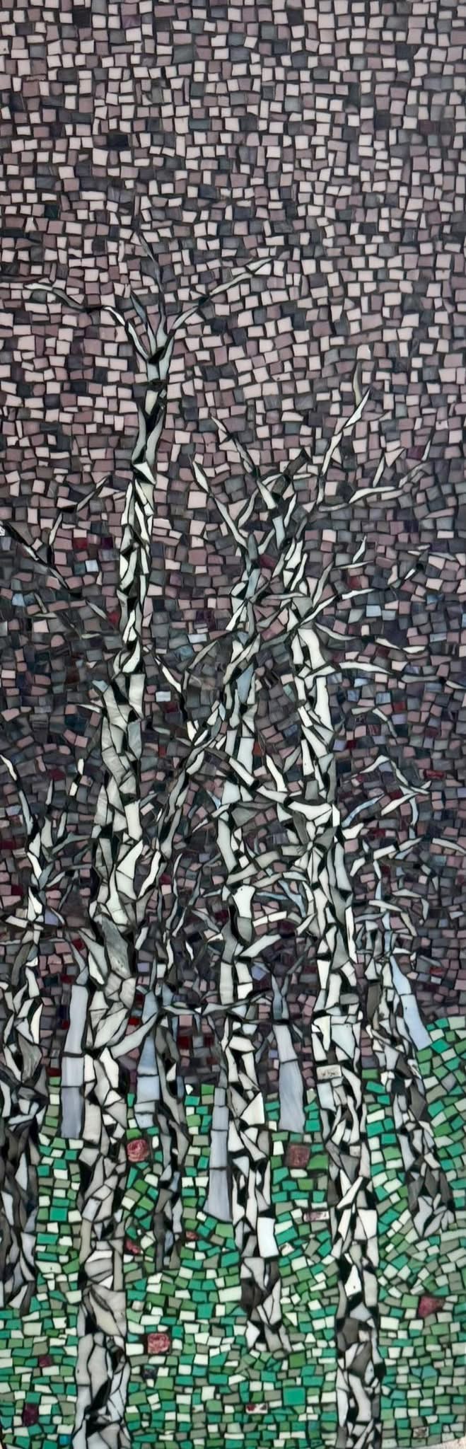 Close-up of a mosaic with black, white, and green tiles, arranged in a pattern resembling plants or trees.