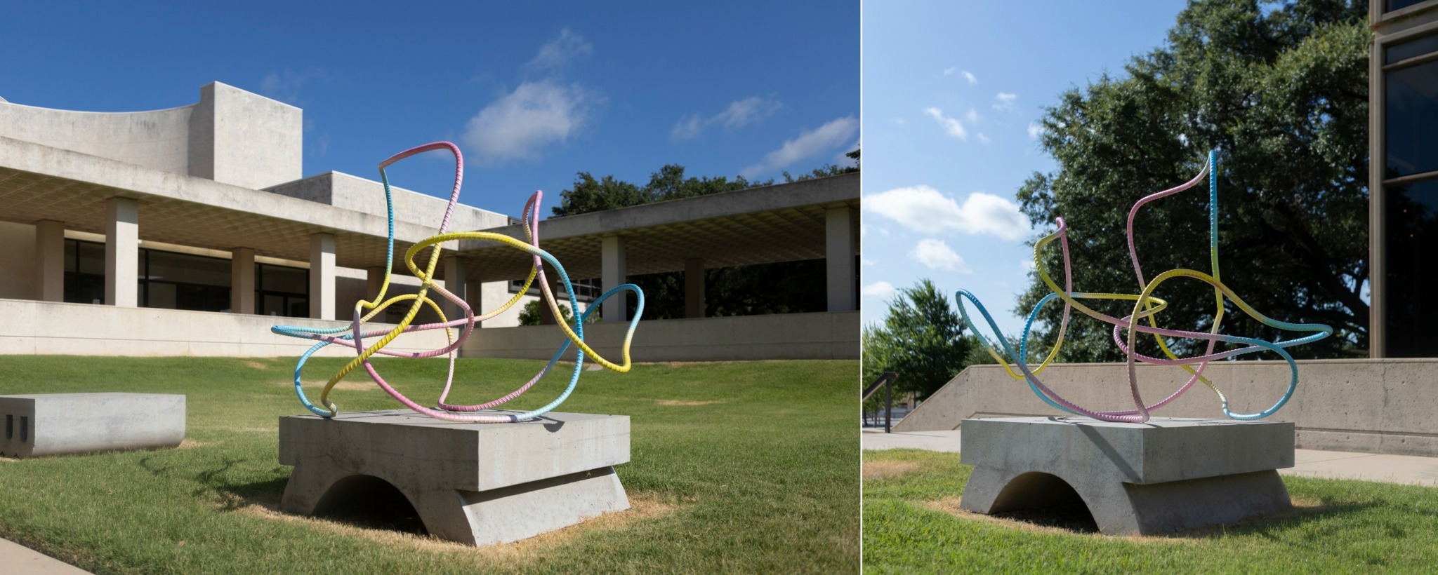 Sculpture of colorful interconnected tubes on a concrete base outdoors, with a building and trees in the background.