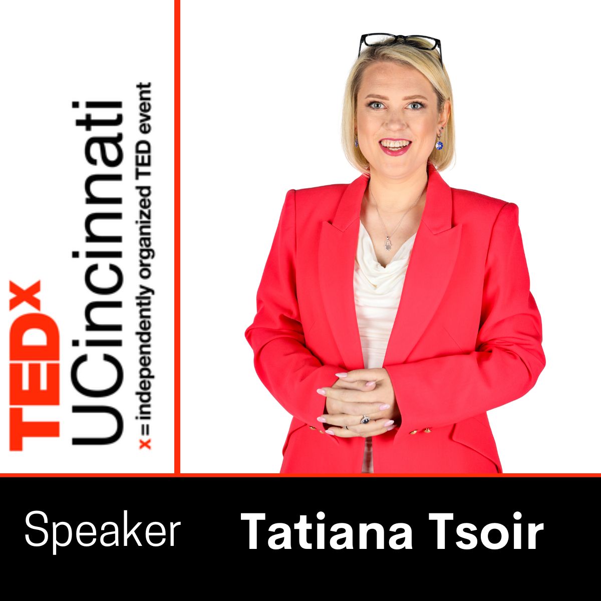 Woman in red blazer smiling, holding hands, with TEDx Cincinnati sign on the left side, glasses on head, white background.