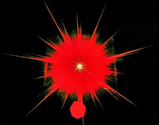 Bright red explosion with streaks radiating outward against a black background.