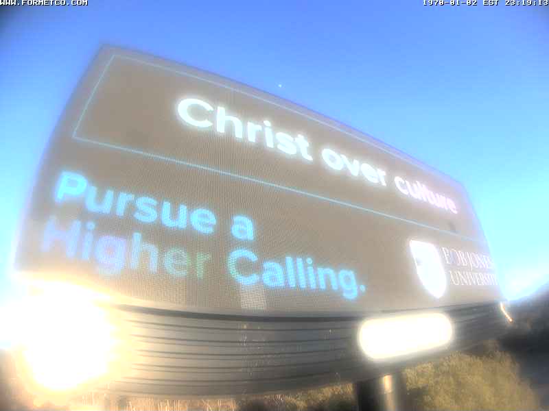 Billboard with text about Christ and pursuing a higher calling, against a blue sky background.