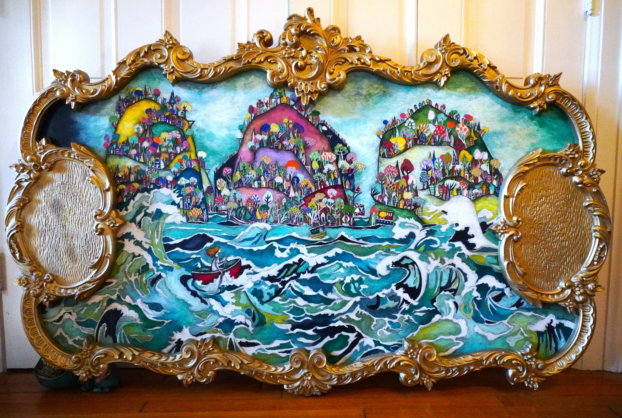 Ornate gold-framed painting depicts a seascape with waves, dolphins, and colorful islands in the background.