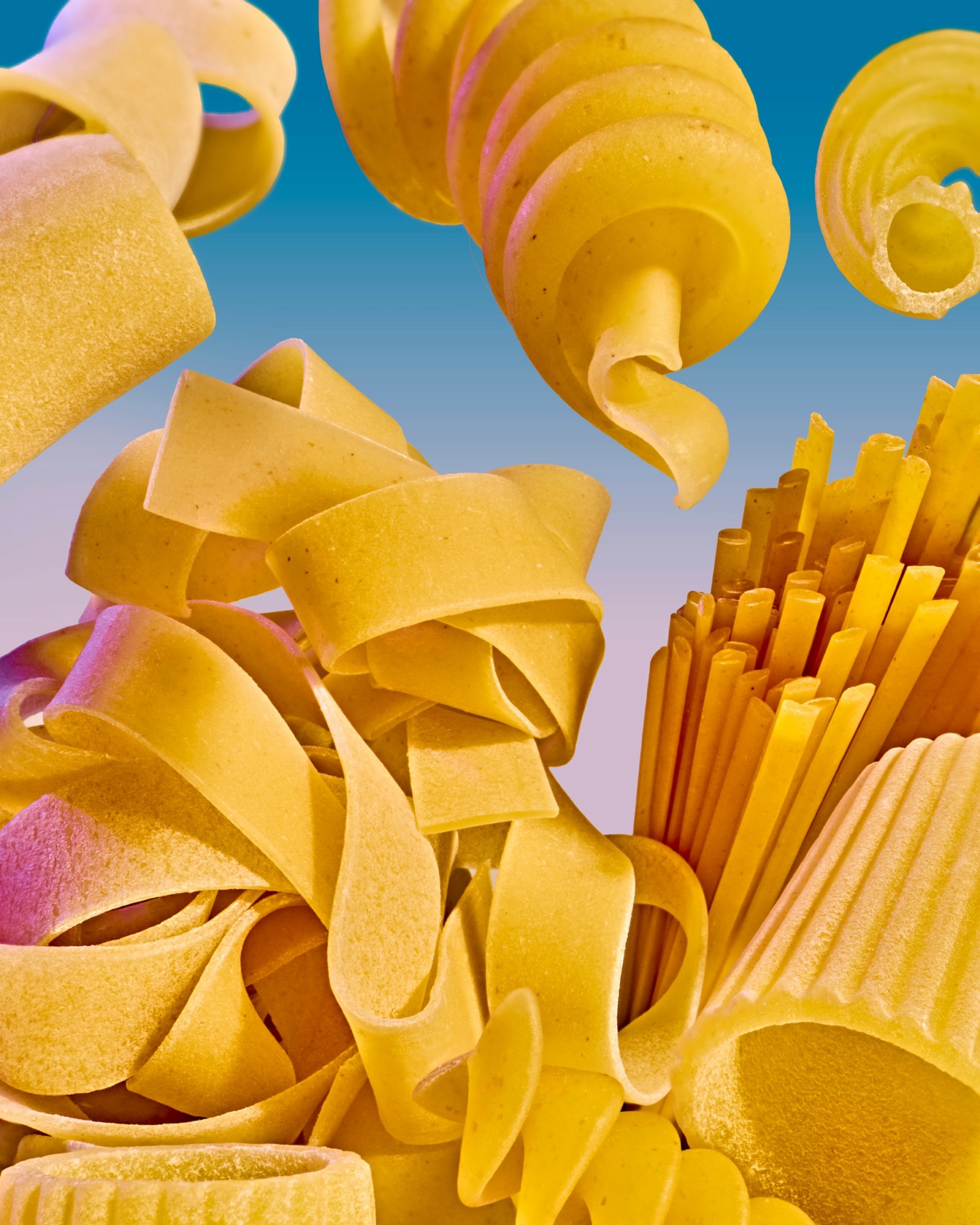 Close-up of various uncooked pasta shapes, including fusilli, spaghetti, and lasagna sheets, against a blue background.