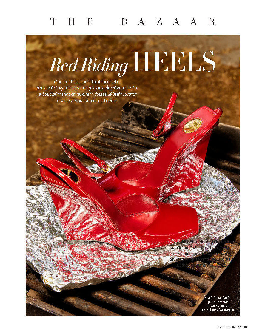 Red high-heeled shoes displayed on a reflective surface with a textured background.