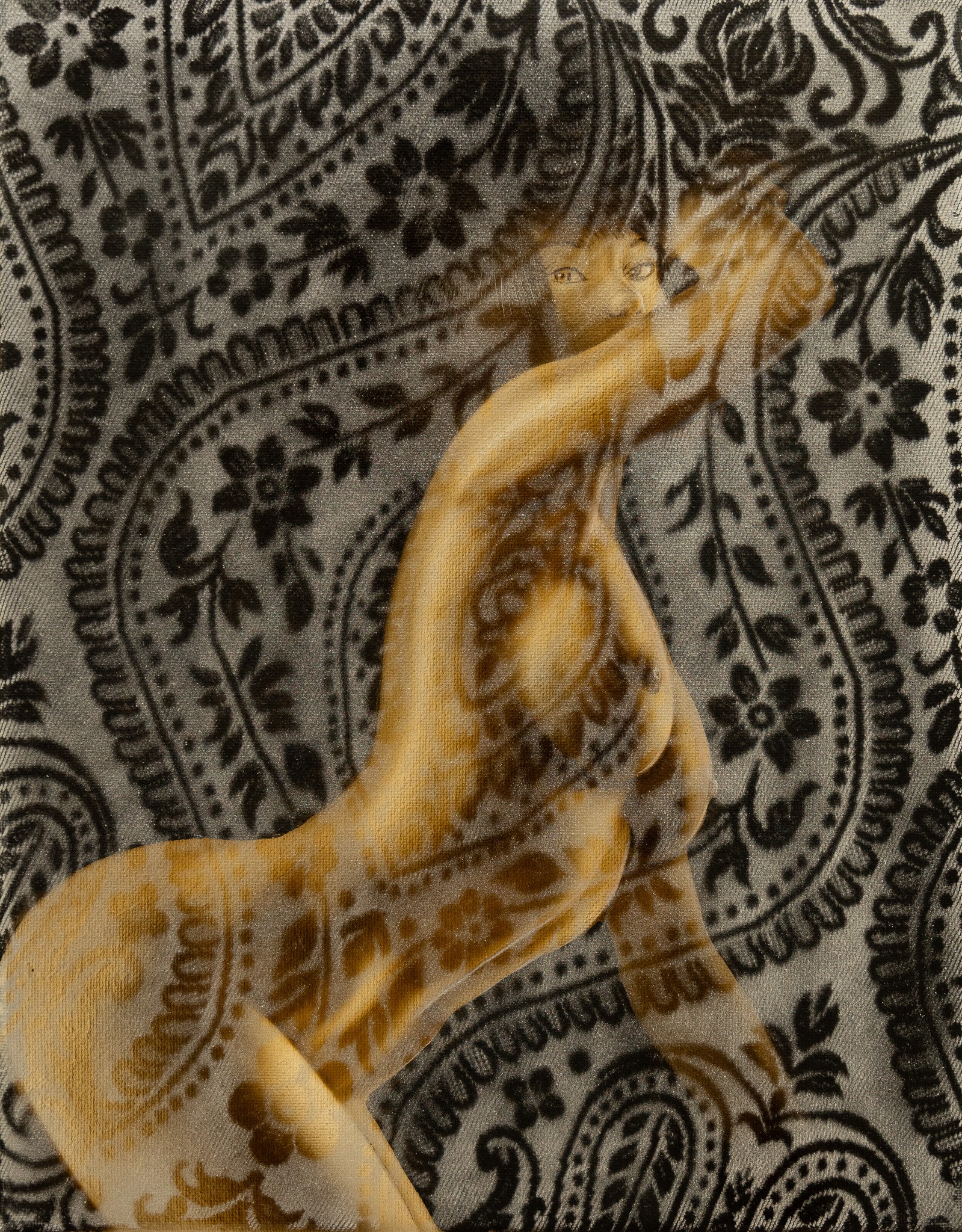 A hand with fingers extended and slightly curved, resting on a patterned fabric background.