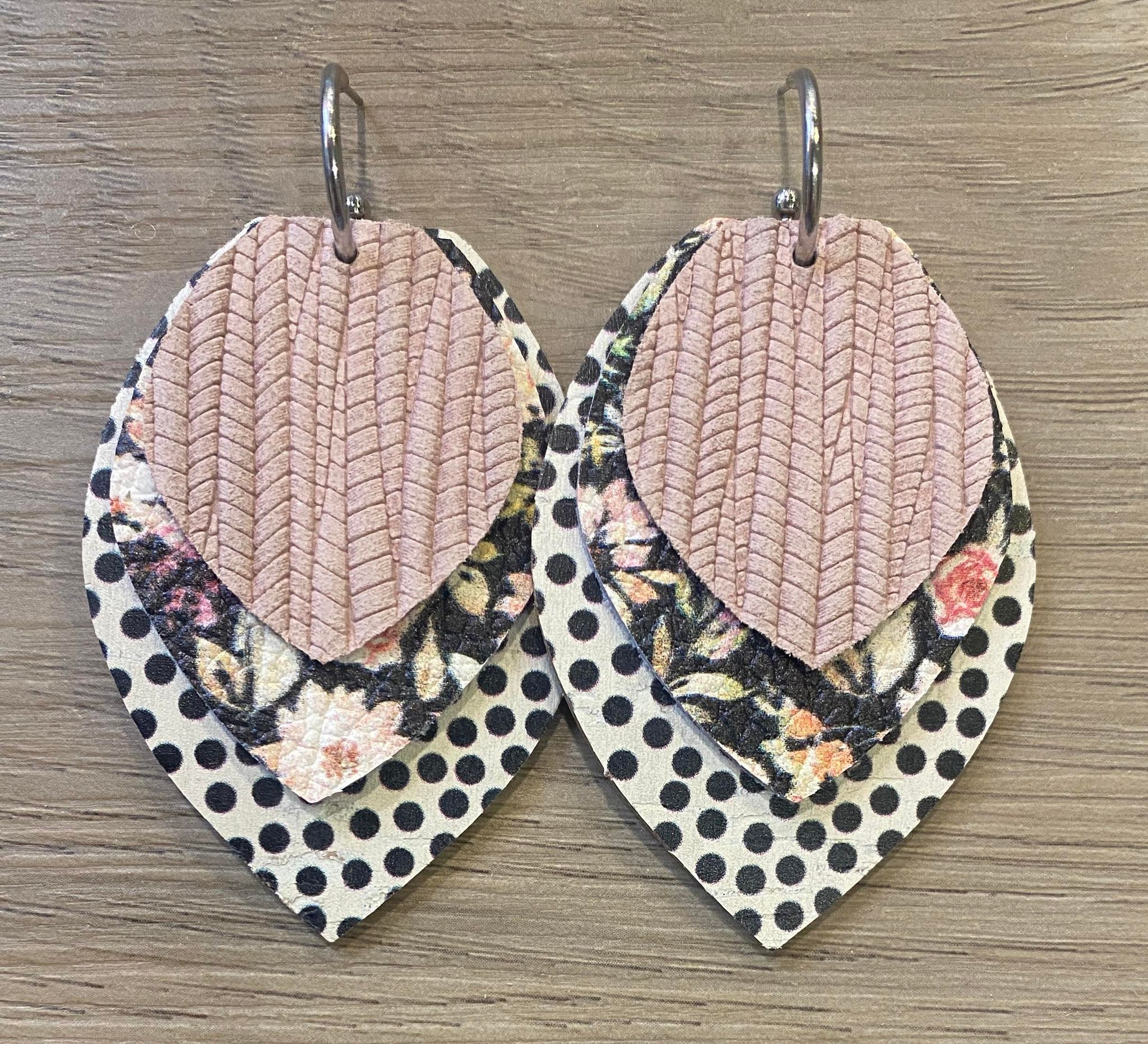 Pair of layered fabric earrings with floral and polka dot patterns, hanging on a wooden surface.